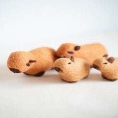Small brown plush toys resembling hedgehogs on a light background