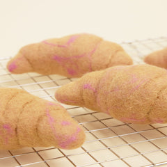 Croissants with pink filling on a cooling rack