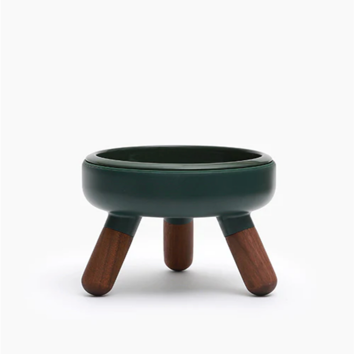 A small round stool or planter with a dark green glazed ceramic bowl and three wooden legs, shown on a clean white background.